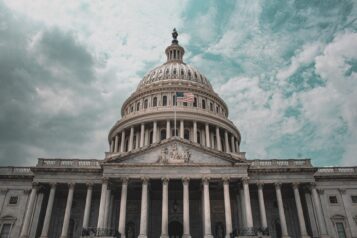 U.S. Capitol against blue sky with white clouds.